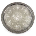 A large Indian white metal tray, circular form, chased and engraved with various figures within a fo