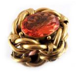 A Victorian yellow metal and peach stone brooch