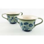 William Moorcroft for James MacIntyre, a pair of Blue Poppy on celadon twin handled cups