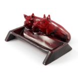 Charles Noke for Royal Doulton, a Flambe Pigs at Trough figure group