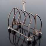 A E Jones, an Arts and Crafts silver four division toast rack, Birmingham 1922