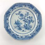 A Chinese export blue and white plate, painted with a floral outdoor scene, 34cm wide