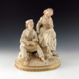 A Victorian parian gilt figure group of a boy and girl tending rabbits, modelled sitting on rocks on