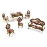 An Austrian gilt metal and enamelled miniature salon suite with a Swiss clock work musical table