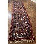 A red ground Persian runner rug W.110cm L.465cm