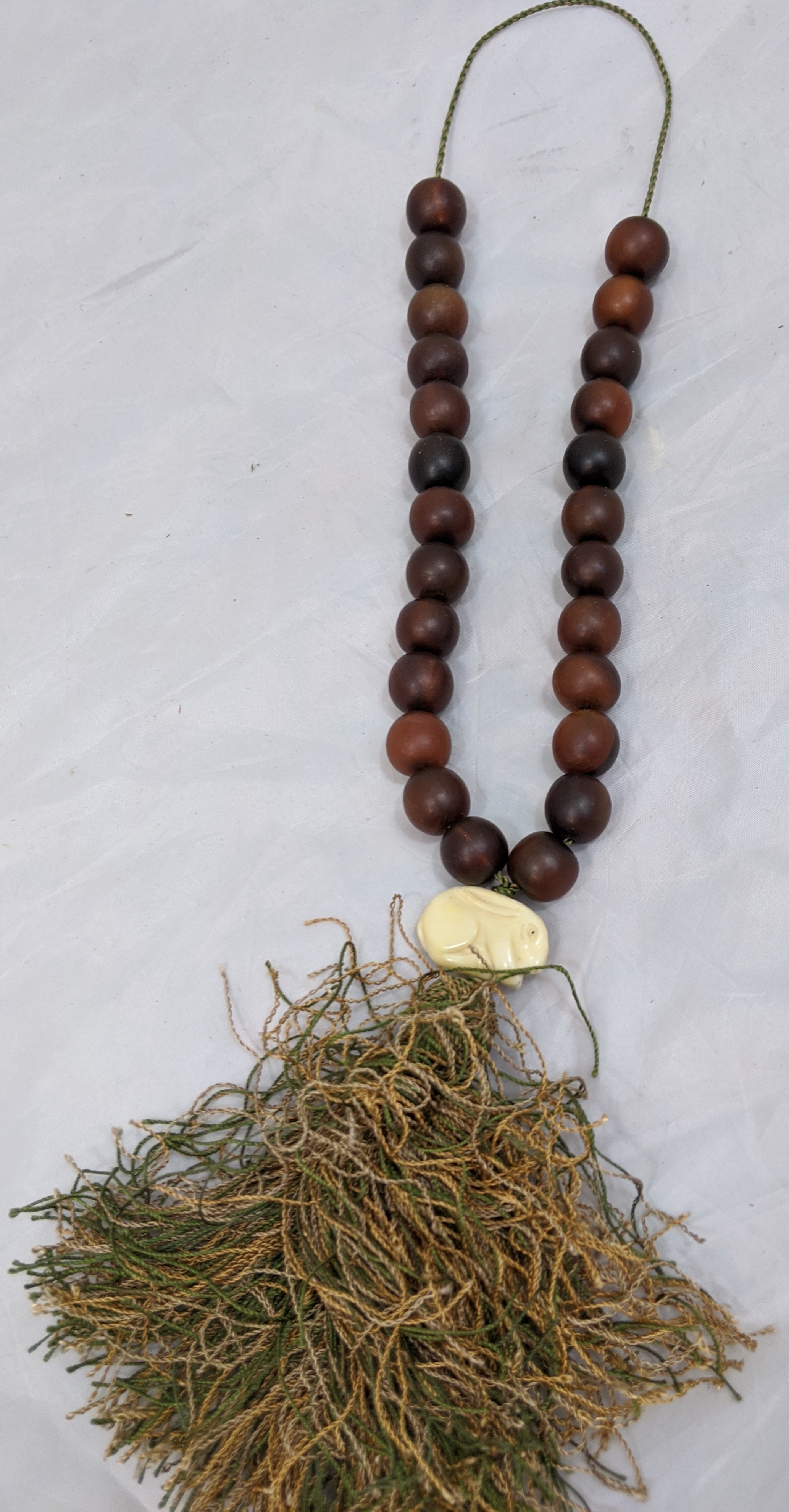 19th century Chinese rhinoceros horn prayer beads, mounted with a carved ivory rabbit and tassel, 25