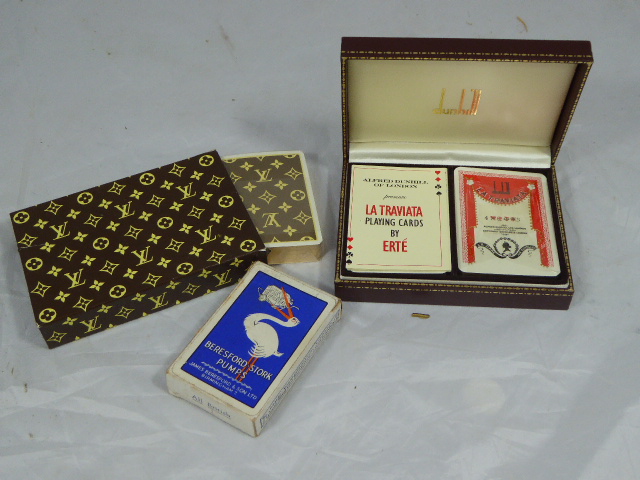 A collection of playing cards to include a leather case Dunhill set and a Louis Vuitton set,