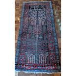 A Persian rug, stylised flora and fauna with a blue and red border, 202cm x 95cm