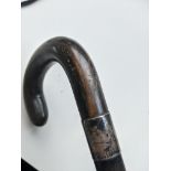 A 19th century/early 20th century walking stick with a rhino horn crook handle and silver collar.