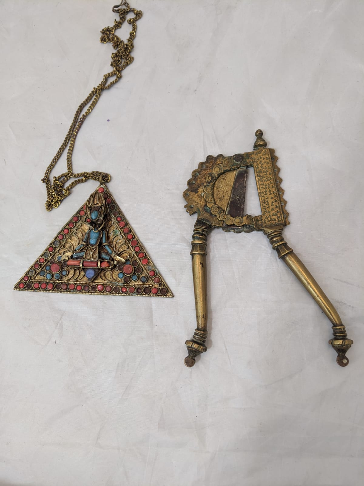 A pair of bronze cutters, together with an Indian, possibly Tibetan, filigree pendant, depicting the