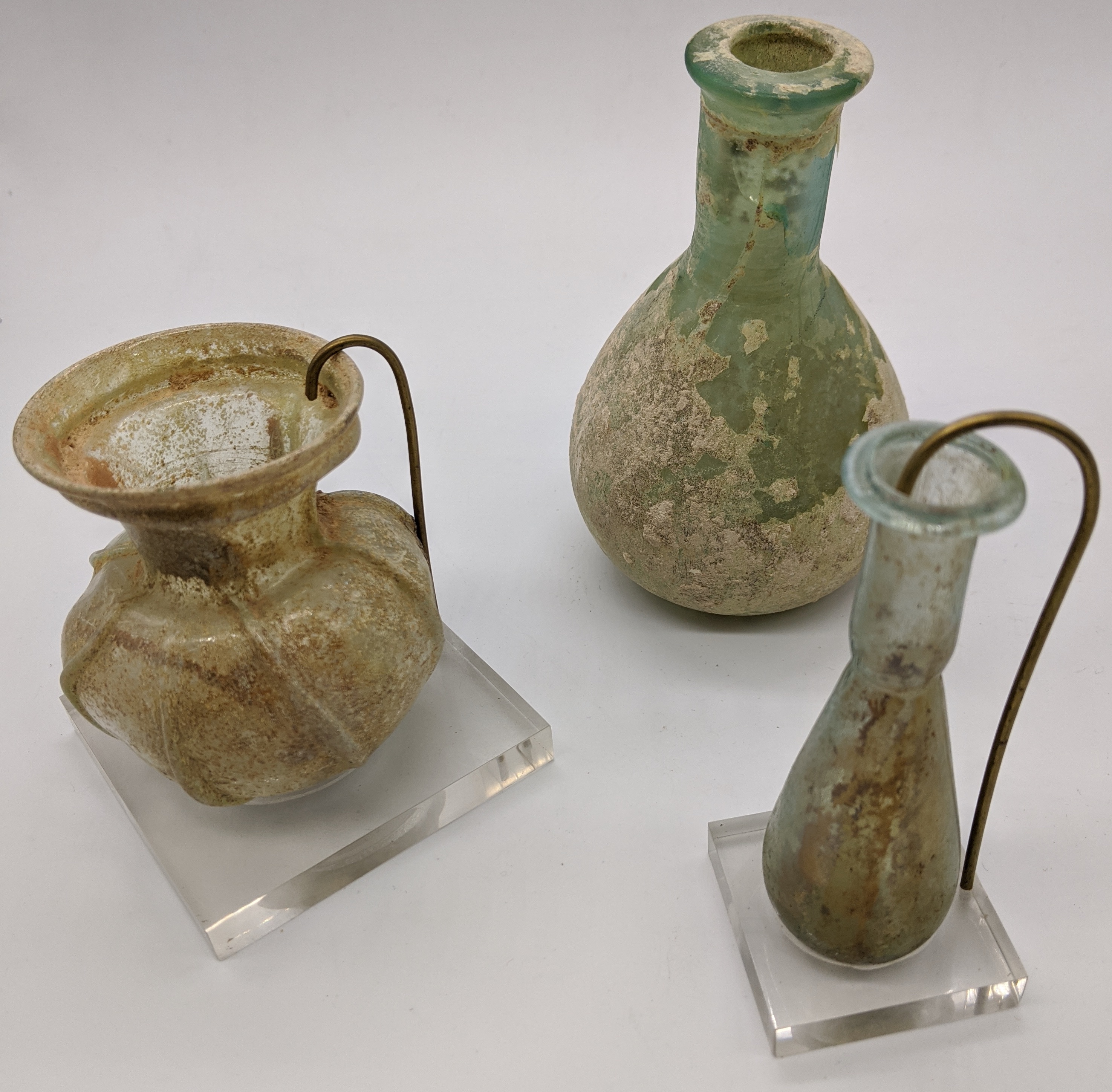 Three Roman glass vases, 1st-3rd century A.D., antiquities interest, Heights 11.5cm, 7cm and 8.5cm