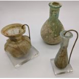 Three Roman glass vases, 1st-3rd century A.D., antiquities interest, Heights 11.5cm, 7cm and 8.5cm