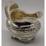 A George III silver cream jug, repousse embossed, hallmarked London, 1820, maker George Hunter II,