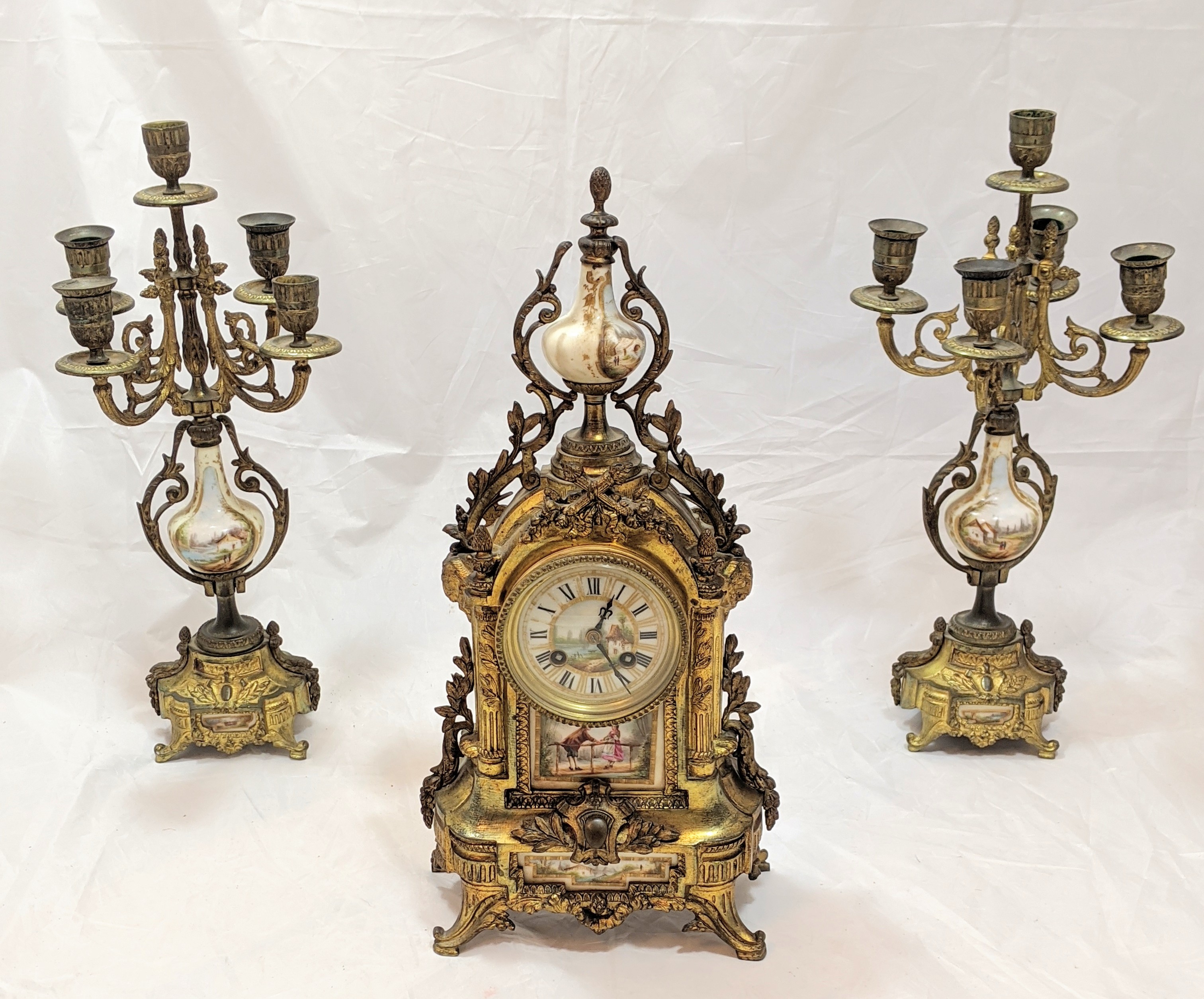 A 19th century Sevres gilt brass clock with garniture, integrated porcelain hand painted bucolic