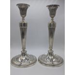 A pair of George III cast round silver candlesticks, shield crests, bead banding, hallmarked