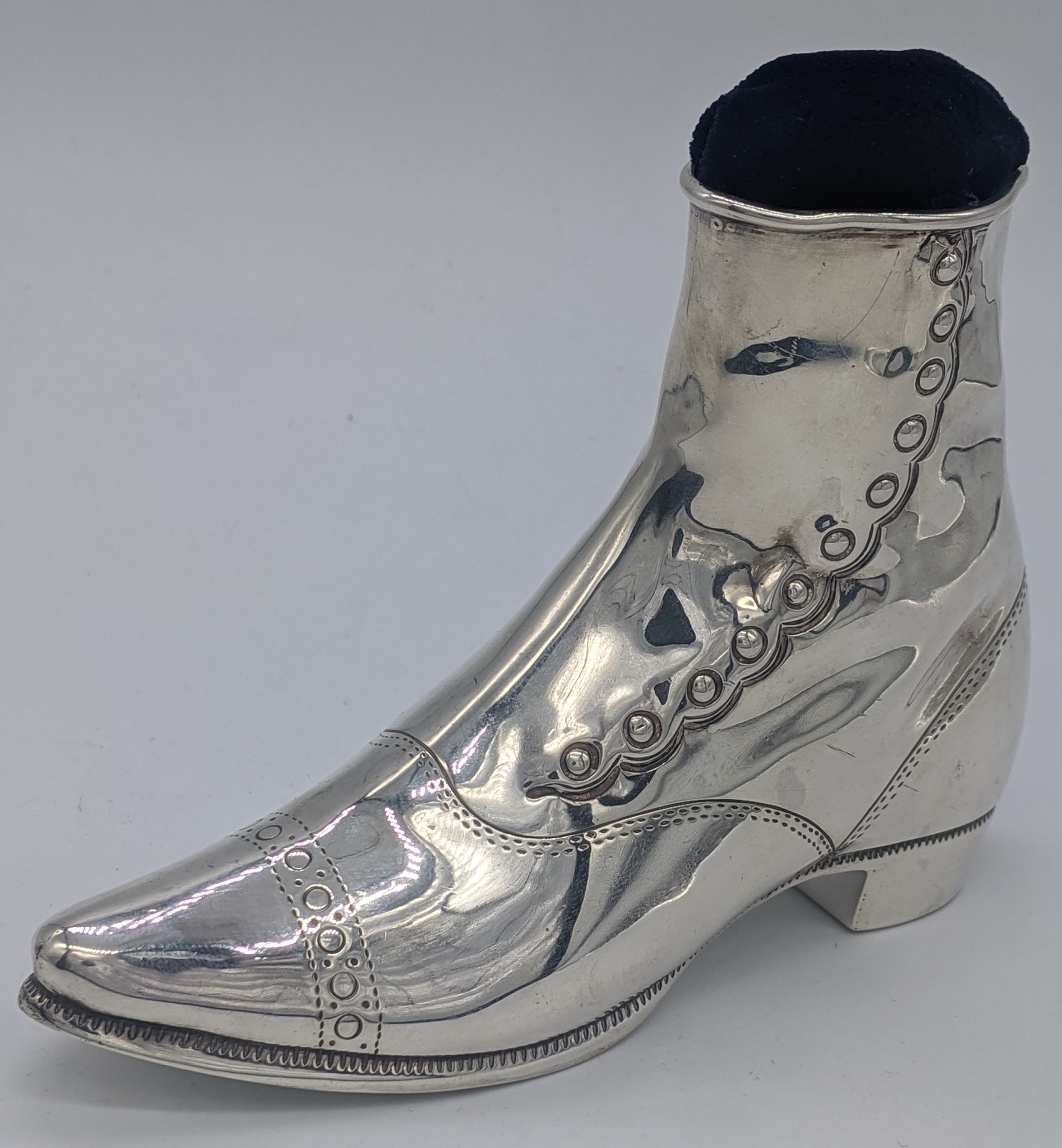 A large silver pin cushion in form of a boot, hallmarked London, 1858, maker John Grinsell & Sons,