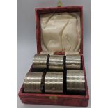 A set of 6 silver napkin rings, stamped `silver`, cased, monogrammed.