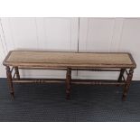 An early 20th century oak window seat, tapered legs and supports