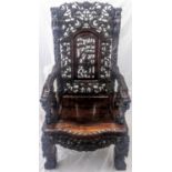 A late 19th century Chinese hardwood armchair, profusely carved with dragons, bats and foliate