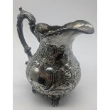 A silver milk jug, repousse embossed, vacant cartouche, hallmarked Chester, 1906, maker Barker