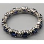 A 14ct white gold eternity ring set with 11 oval cut sapphires and 11 round cut diamonds, stamped