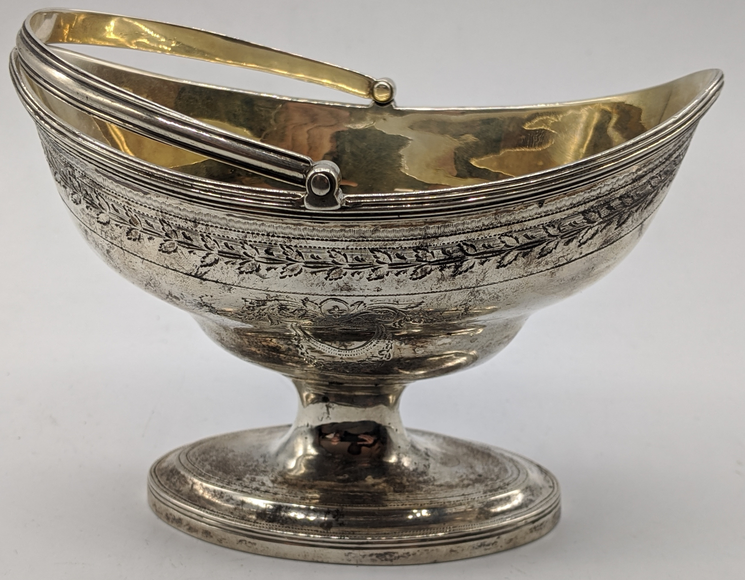 A George III silver sugar basket by George Burrows, gilt interior, vacant cartouches, swing