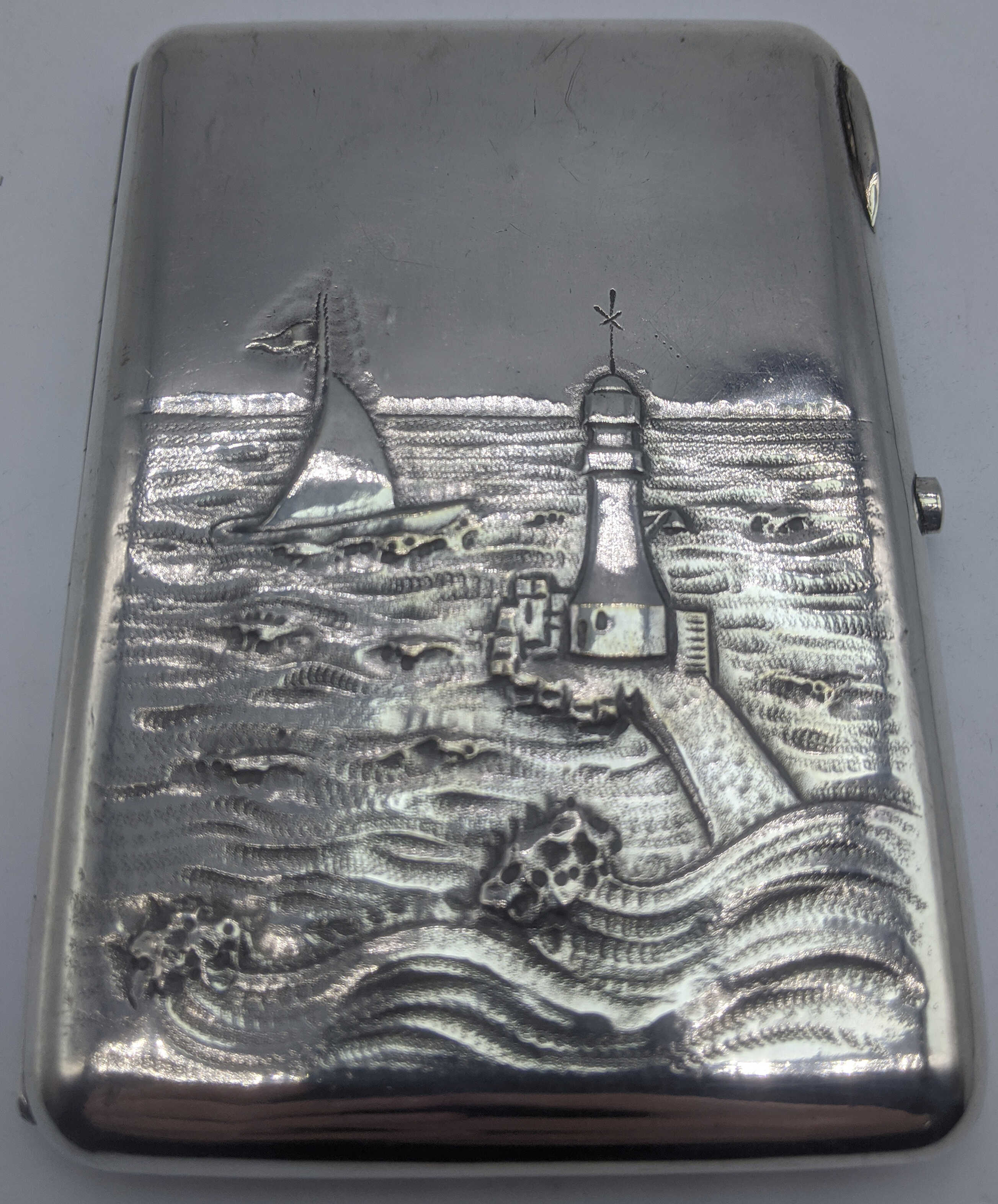 A Russian silver case depicting a lighthouse and yacht at sea, gilt interior, marks to the interior,