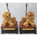 A pair of Chinese gilt wooden dogs of fo, raised on stand, converted to electric lamps, early 20th