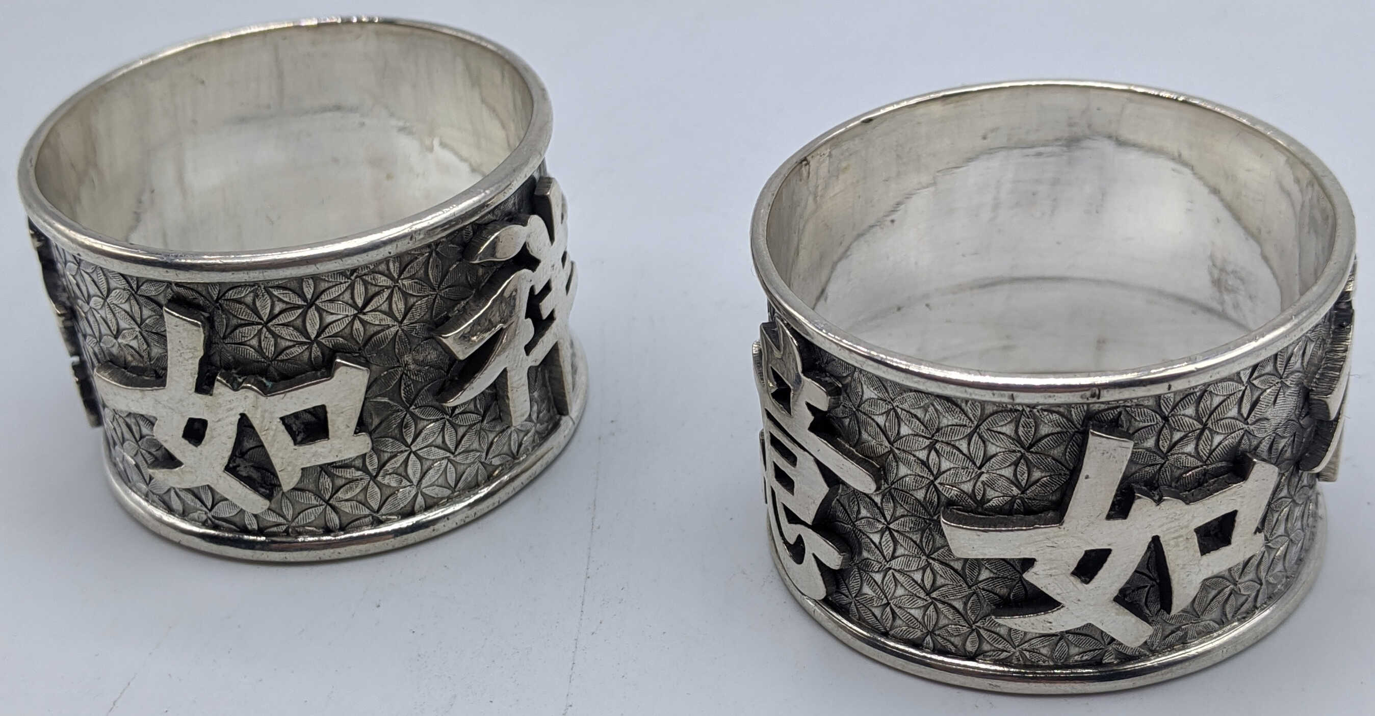 A pair of Chinese silver napkin rings, character marks and vacant cartouche, marks to the inside