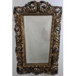 A Florentine carved giltwood mirror, bevelled glass, early 20th century, H.125cm W.89cm (at widest