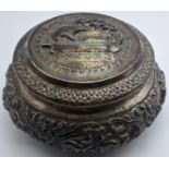 A Burmese silver box, embossed with a ship to the lid, scenes to the middle of elephants, cows and