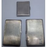 Three early 20th century Deco silver cigarette cases, engine turned outers, gilt interiors,