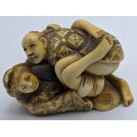 A late 19th century Japanese Ivory Shunga erotic netsuke of a couple in an amorous embrace, signed