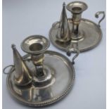 A pair of George III silver chambersticks, crests to the interior bowls, the bases and inserts
