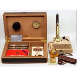 An S.T.Dupont cigar humidor, a S.T.Dupont lighter together with a collection of cigars, a trench