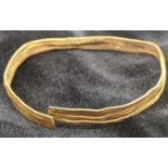 A 24ct gold Celtic or bronze age pennanular torc/bangle/bracelet, antiquities interest, 12g, H.6.5cm