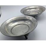 A pair of Queen Anne pewter dishes, raised on three feet in the form of grotesque faces,