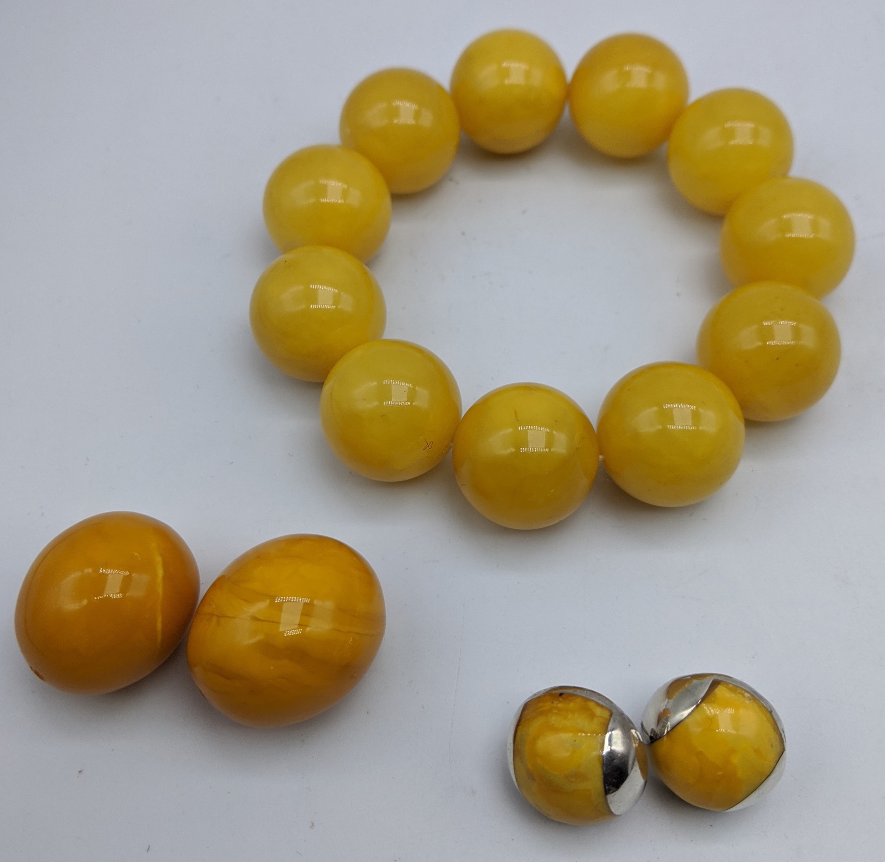 An amber bead bracelet (51g), together with two amber beads (13g) and a pair of amber earrings