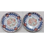 A pair of Chinese 19th century plates depicting a red five claw dragon surrounded by blue and