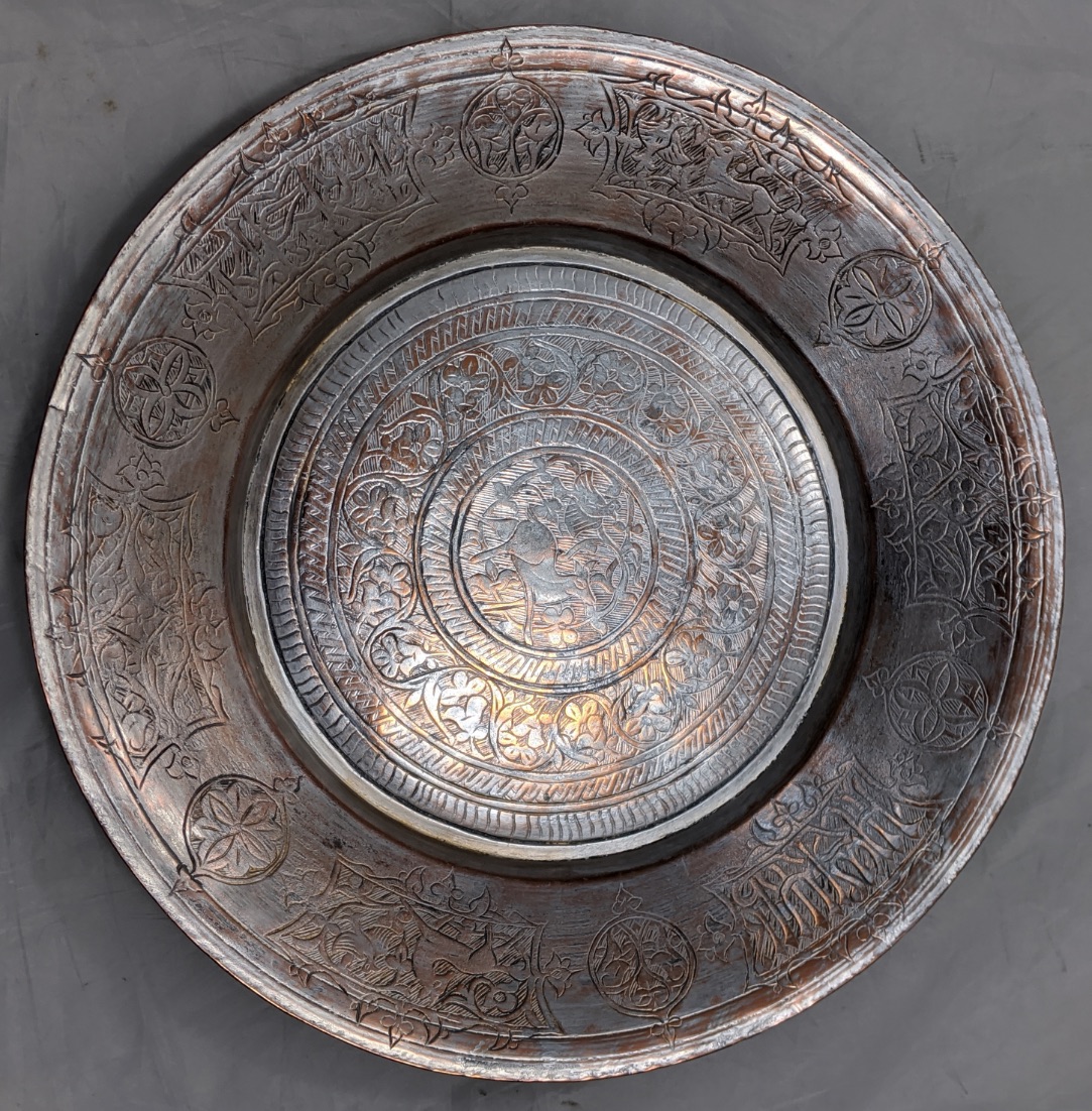 An early 20th century Persian silvered copper bowl, etched with scrolling patterns and animals, D.