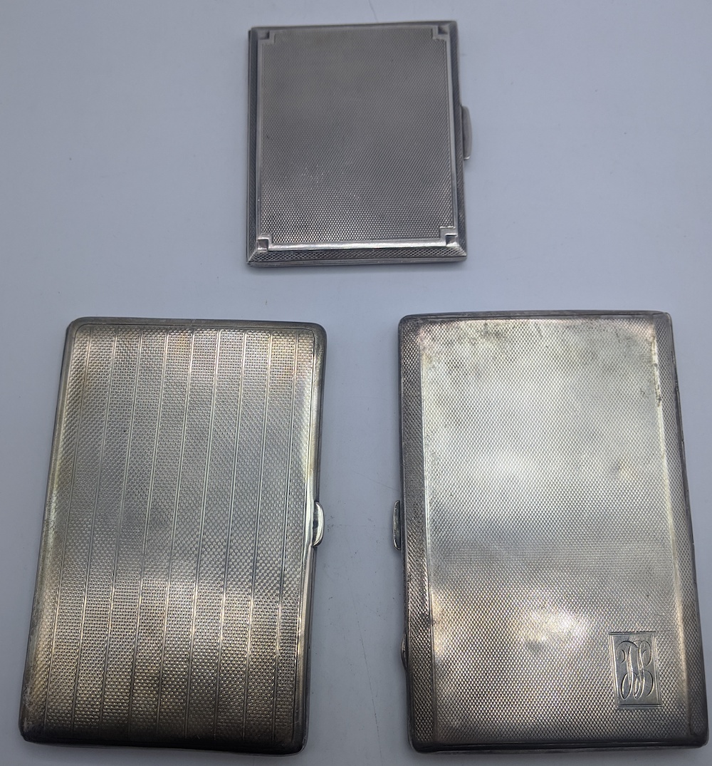 Three early 20th century Deco silver cigarette cases, engine turned outers, gilt interiors,