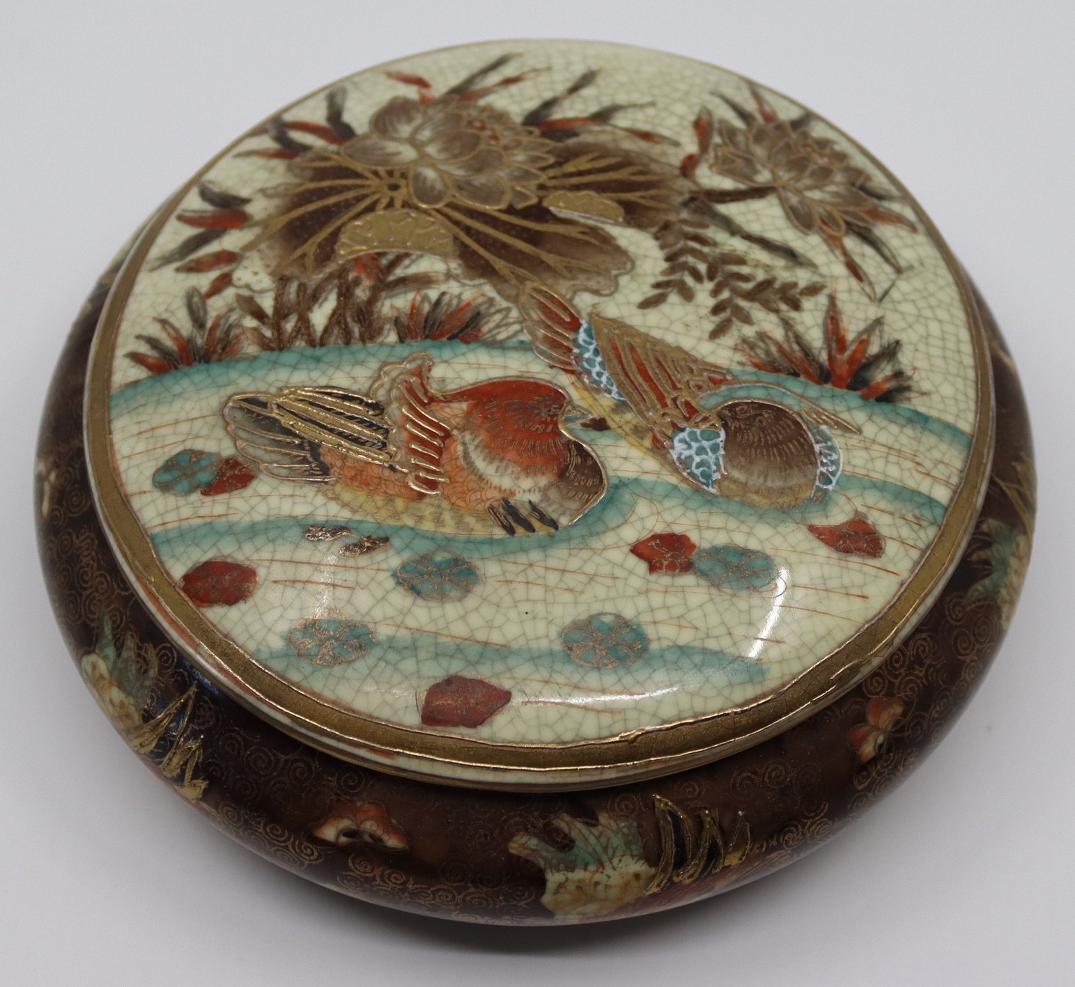 A Japanese satsuma porcelain bowl with lid depicting mandarin ducks, bearing character mark to base