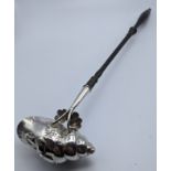 An 18th century Germanic toddy ladle in the form of a shell depicting a nobleman, embossed with