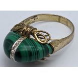 A 14ct yellow gold ring mounted with malachite and central band of small diamonds, 6.9g,