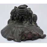 A Japanese 19th century bronze depicting a man chasing a mythical beast under a conical hat, H.4.5cm