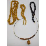 Three amber bead necklaces and a tribal necklace with an amber bead