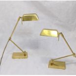 A pair of gold coloured adjustable desk lamps