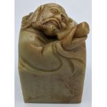 A Chinese 19th century soapstone stamp, the top in the form of a Chinese scholar, etched character