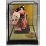 A Japanese doll within case together with a Japanese puppet, H.55cm W.38cm