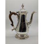 A George III silver coffee pot, crest of a hand holding an anchor to both sides, wooden handle,